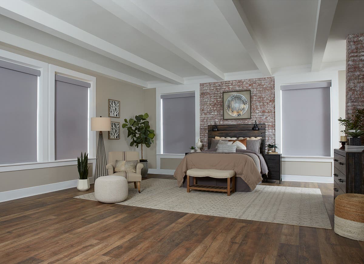 Spacious modern bedroom with light gray motorized roller shades fully closed